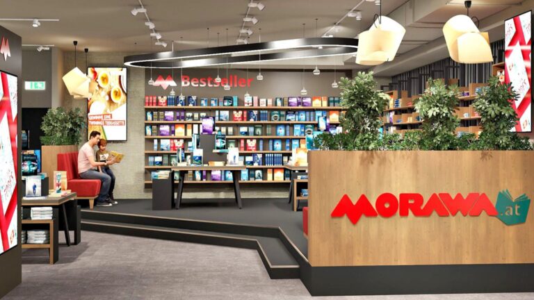 Zu sehen ist das Innere einer Buchhandlung. Bücher stehen in Regalen. Ein Erwachsener liest einem Kind in einer Sitzecke vor. Im Vordergrund prangt der Schriftzug der Morawa.