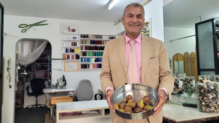 Ilyas Rumanus steht in seiner Schneiderei und hält eine Schale seiner Feigen in die Kamera.