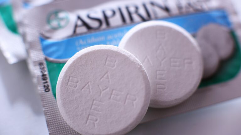 Zwei Aspirin-Brausetabletten liegen auf einer Aspirin-Verpackung.