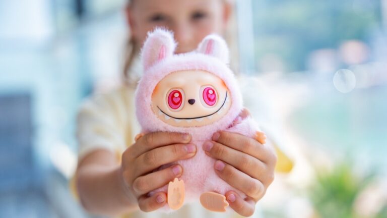 Ein Kind hält eine Labubu-Plüschfigur des chinesischen Herstellers Pop-Mart in die Kamera.
