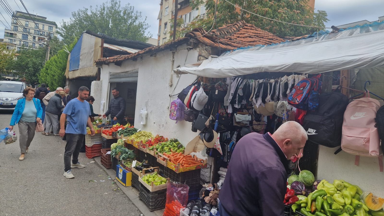 Markt auf einer Straße mit Lebensmittelständen, Verkäufern und Kunden