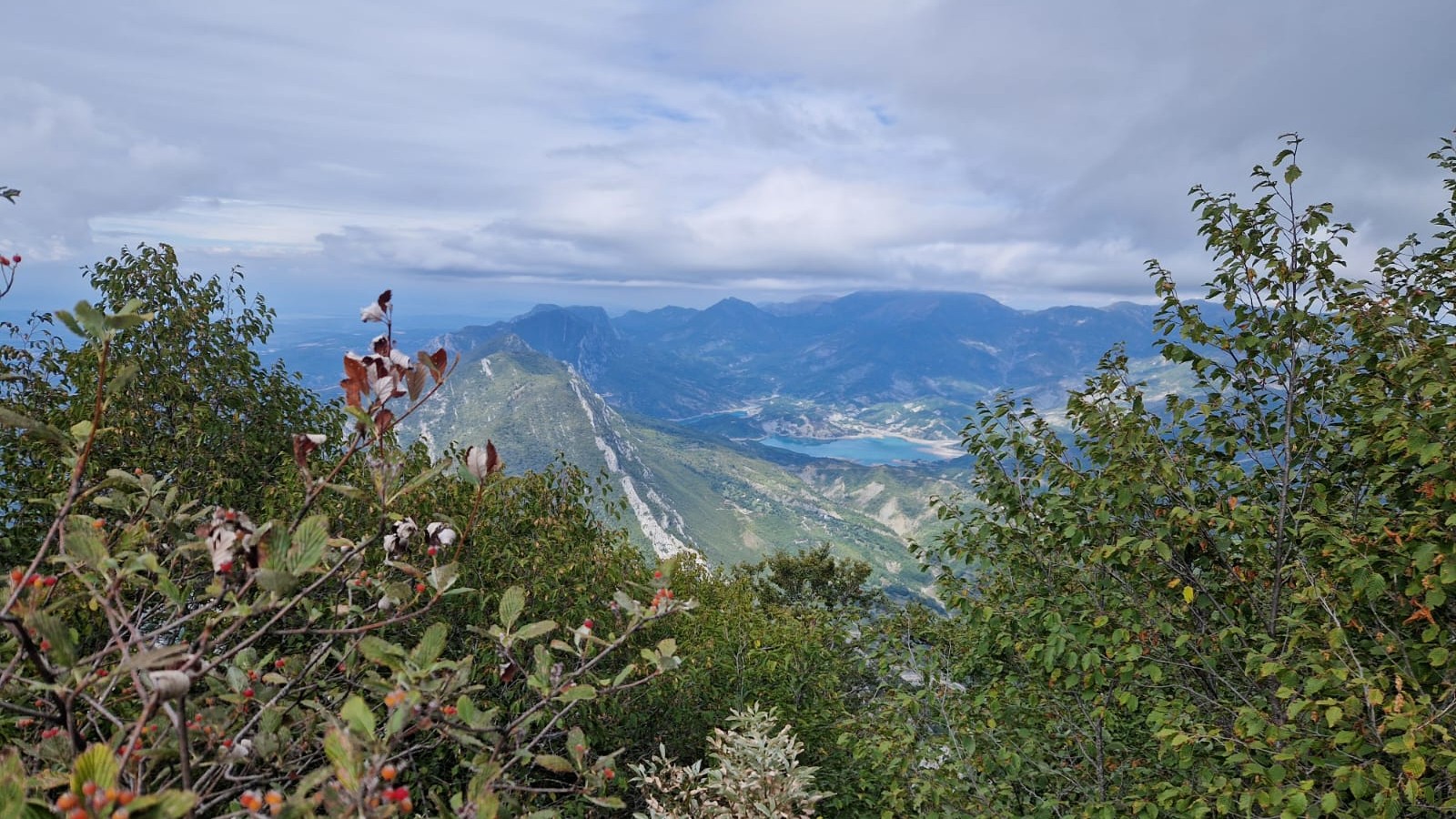 Aussicht aufs Tal mit einem kleinen See, umringt von Bergen