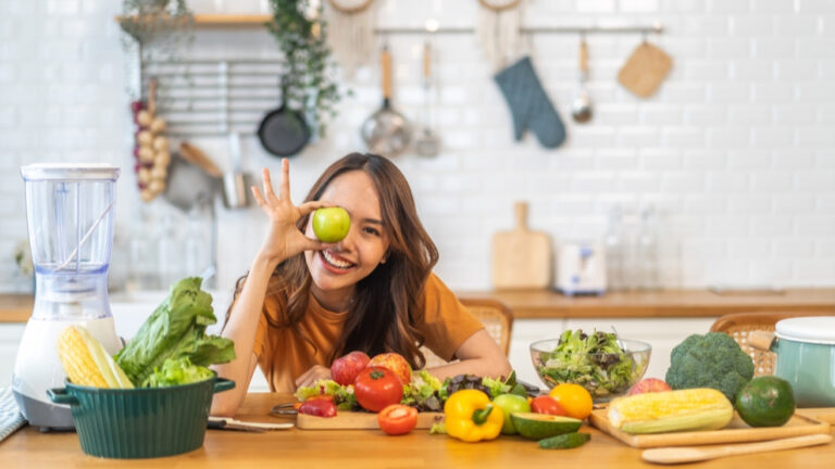 Glückliche junge Frau mit veganen Lebensmitteln