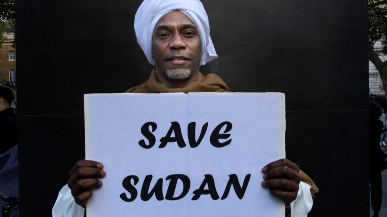 Mann mit Schild „Save Sudan“